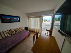 a living room with a couch and a dining room table at Depto AC Olavarria in Olavarría