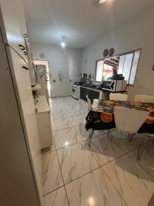 a kitchen with a refrigerator and a table with chairs at Suite in Catanduva