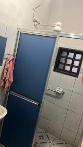 a blue door in a bathroom with a window at Suite in Catanduva
