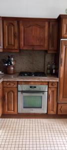 a kitchen with wooden cabinets and a stainless steel oven at Coquette maison in Dunkerque