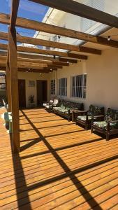 a large deck with couches and a wooden floor at Residencial Marilis in Palhoça