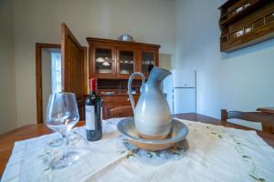 a table with a vase and a bottle of wine at La casina di Zora in Lorenzana