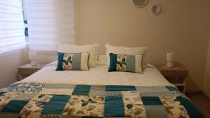 a bedroom with a bed with a quilt and pillows at Chillan Centro in Chillán