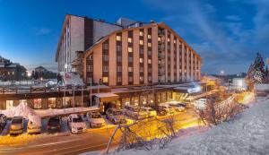 ウルダグにあるGrand Yazici Ski Hotel & Spaの駐車場車の入った建物