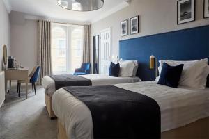 a hotel room with two beds and a desk at The Burlington in Worthing