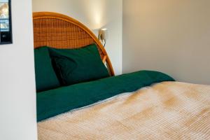 a bed with a green blanket on top of it at Studio Esterinkatu in Imatra
