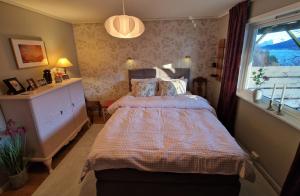 a bedroom with a bed and a window at Hessahuset in Ålesund