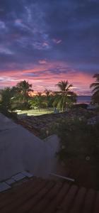 a sunset over a beach with palm trees at MANDALA DREAMS Pousada e Portal Holístico in Maceio