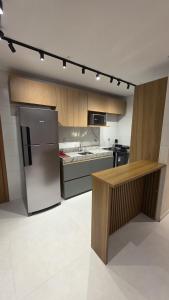 a kitchen with a stainless steel refrigerator and a counter at Ipioca Beach Life Maceió beira mar in Maceió