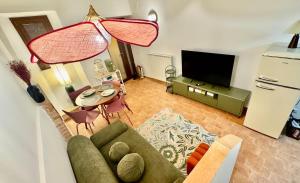 a living room with a couch and a television at Pink House - InBorgo in Acquasparta