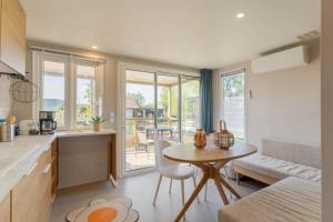 a kitchen and living room with a table and chairs at Camping Papillon Kinrooi - Vakantiehuis Premium 4P in Kinrooi +8 photos
