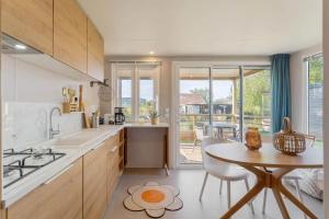 a kitchen with a table and a dining room at Camping Papillon Kinrooi - Vakantiehuis Premium 4P in Kinrooi