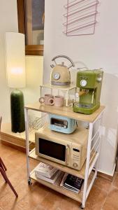 a table with a microwave and a sewing machine on it at Pink House - InBorgo in Acquasparta
