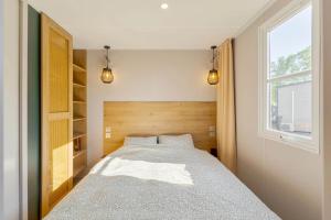 a bedroom with a bed and a window at Camping Papillon Kinrooi - Vakantiehuis Premium 4P in Kinrooi