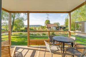 a screened in porch with a table and chairs at Camping Papillon Kinrooi - Vakantiehuis Premium 4P in Kinrooi
