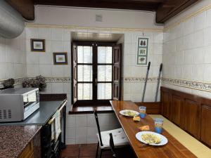 a kitchen with a table and a microwave at El Refugio del Busgosu in Pen