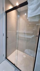 a glass shower door with a toilet in a bathroom at Stúdio FRENTE MAR Centro de Convenções Salvador ArtStudio in Salvador +27 photos