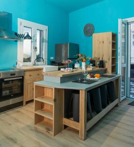 a kitchen with blue walls and a table with food on it at The Urban Parrot Maisonette in Ermoupoli