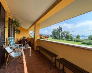a balcony with a large window and a table and chairs at Home Nature and Relax in Monte del Lago