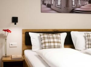 a bedroom with a bed with white sheets and pillows at Doppelzimmer 10 in Heidenheim