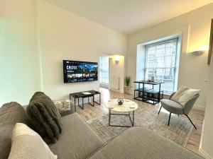 a living room with a couch and a tv at The Tay Residence, City Centre in Perth