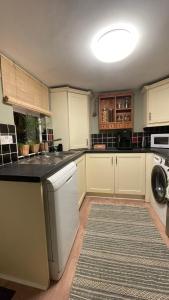a kitchen with white cabinets and a rug at Anyas rooms Ltd in Antrim