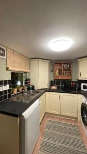 a kitchen with white cabinets and a black counter top at Anyas rooms Ltd in Antrim +23 photos