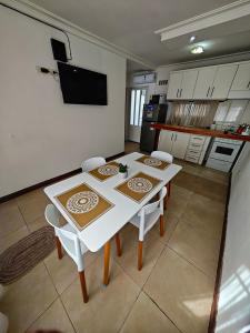 a kitchen with a white table and chairs in a room at Dpto URQUIZA Olavarría in Olavarría