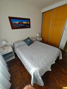 a small bedroom with a bed and a wooden cabinet at Dpto URQUIZA Olavarría in Olavarría