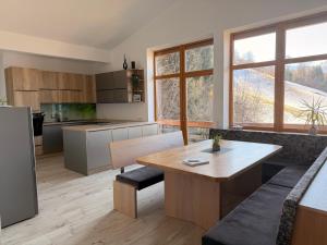 a kitchen with a wooden table and a kitchen withwindows at Gruberhof in Pill