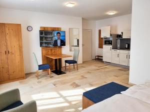 a room with a table and chairs and a kitchen at Appartement 1 mit Terrasse in Wehlenberg +11 photos