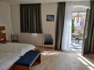 a bedroom with a bed and a chair and a window at Appartement 1 mit Terrasse in Wehlenberg