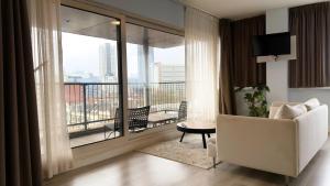 a living room with a white couch and a balcony at Rotterdam Teleport Hotel in Rotterdam
