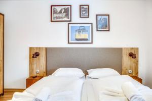 two beds in a room with pictures on the wall at Dormio Hotel Obertraun in Obertraun +30 photos