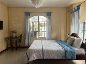 a bedroom with a large bed and a window at Brussels Garden Inn in Lagawe
