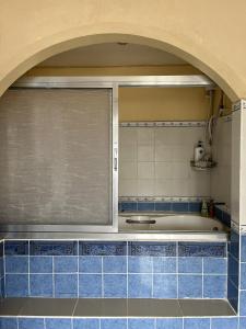 a kitchen with a window and blue tiles at Brussels Garden Inn in Lagawe