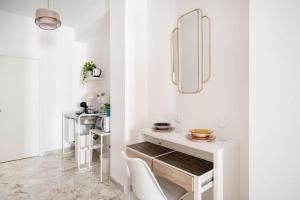 a white dining room with a table and chairs at AuGuStea - Modern Central Suites in Bari +37 photos