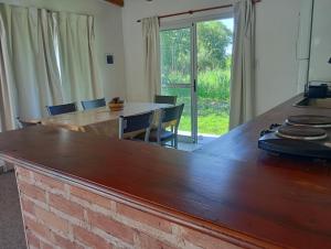 a kitchen with a large wooden counter top with chairs at Casa Colmena Turismo Rural in Londres