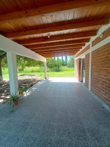 an empty patio with a wooden roof and a brick wall at Casa Colmena Turismo Rural in Londres