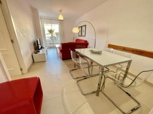 a living room with a table and red chairs at Plaza España - Central 3 Bedroom apartment - LUAL in Nerja