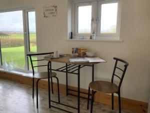 a table and two chairs in a room with a window at Villa Farm Cottage in Thornton Curtis