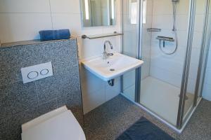 a bathroom with a sink and a shower at Ferienhaus Bellevue in Bensersiel +30 photos