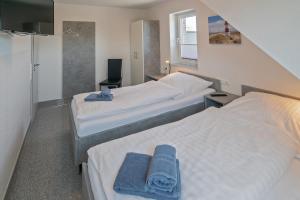 a hotel room with two beds with towels on them at Ferienhaus Atika in Bensersiel