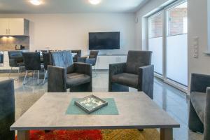 a waiting room with a table and chairs and a tv at Ferienhaus Caskade in Bensersiel