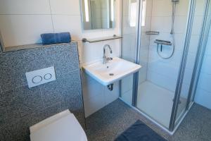a bathroom with a sink and a shower at Ferienhaus Caskade in Bensersiel +28 photos