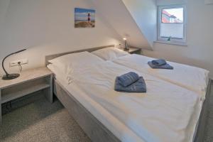 a bedroom with a bed with two towels on it at Ferienhaus Caskade in Bensersiel
