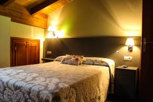a bedroom with a bed and two lights on the wall at Casa Rural Las Bodegas II in Valbuena de Duero
