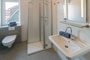 a bathroom with a shower and a sink and a toilet at Ferienhaus Empora in Bensersiel +27 photos