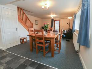 a dining room with a wooden table and chairs at Cragg Hall View in Mytholmroyd
