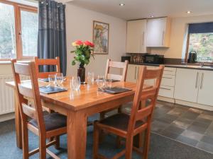 a kitchen with a wooden table with wine glasses at Cragg Hall View in Mytholmroyd